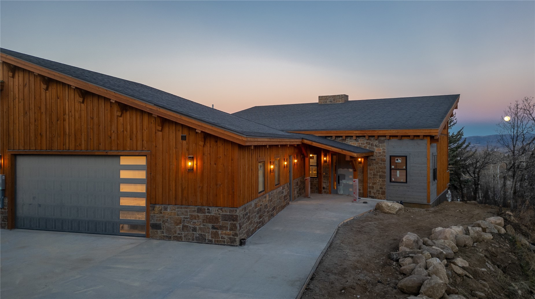 200 Sundance Court, Unit 1 Steamboat Springs, CO 80487 - Photo 44 of 50 View of front of property with stone siding, a chimney, a shingled roof, and driveway