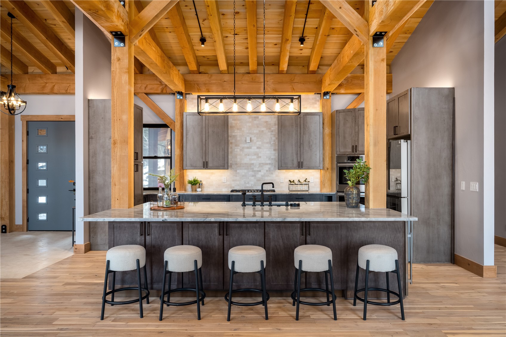 200 Sundance Court, Unit 1 Steamboat Springs, CO 80487 - Photo 10 of 50 Kitchen with a wooden ceiling with exposed beams, light stone countertops, a breakfast bar area, a spacious island, and decorative light fixtures