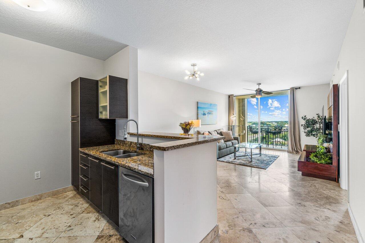 a kitchen with stainless steel appliances granite countertop a stove refrigerator and a dining table view