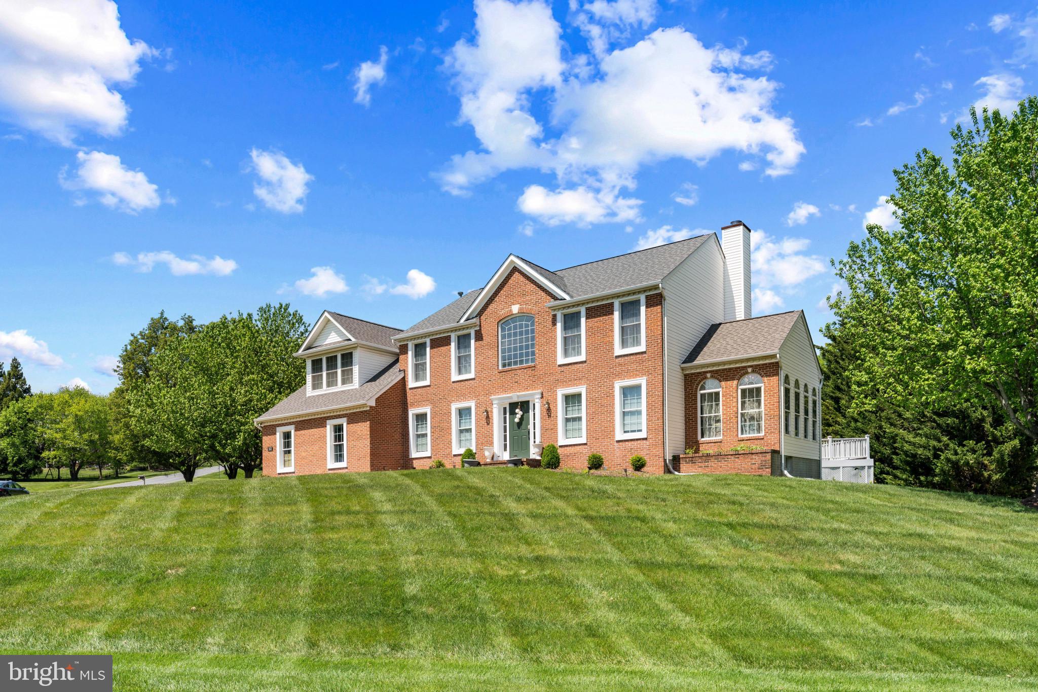 Charming brick home on lush green lawn.