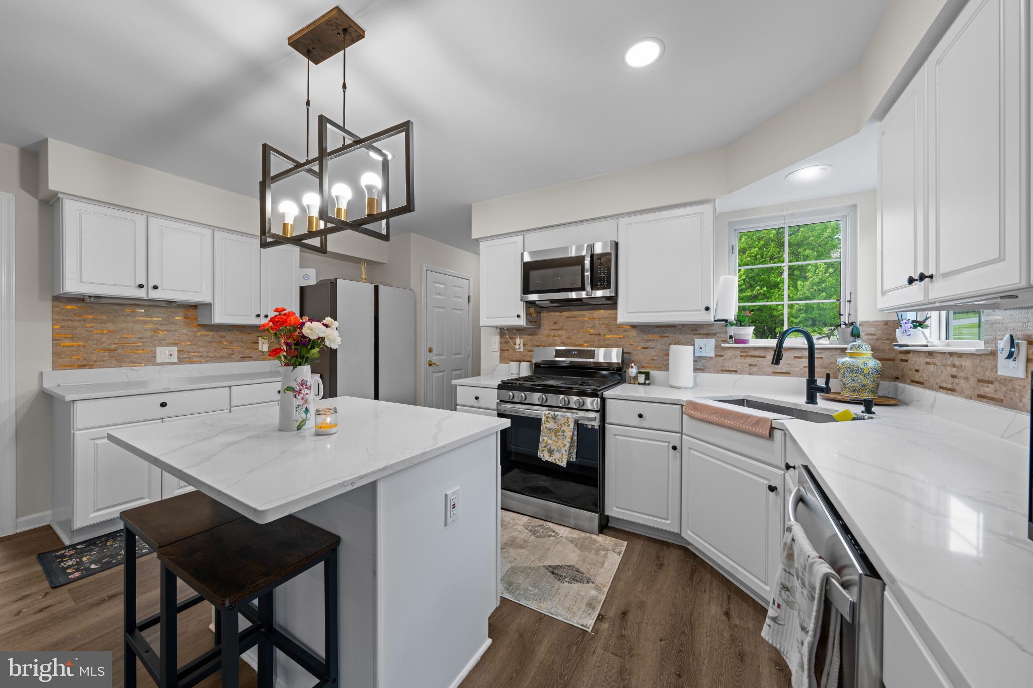 4132 Larson Lane Mount Airy, MD 21771 - Photo 11 of 36 a kitchen with stainless steel appliances granite countertop a sink dishwasher a stove a refrigerator a microwave oven with a dining table and chairs