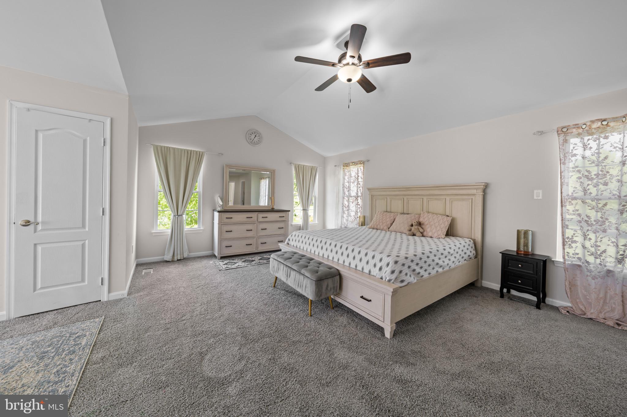 4132 Larson Lane Mount Airy, MD 21771 - Photo 21 of 36 a bed sitting in a spacious bedroom next to a window and a chandelier