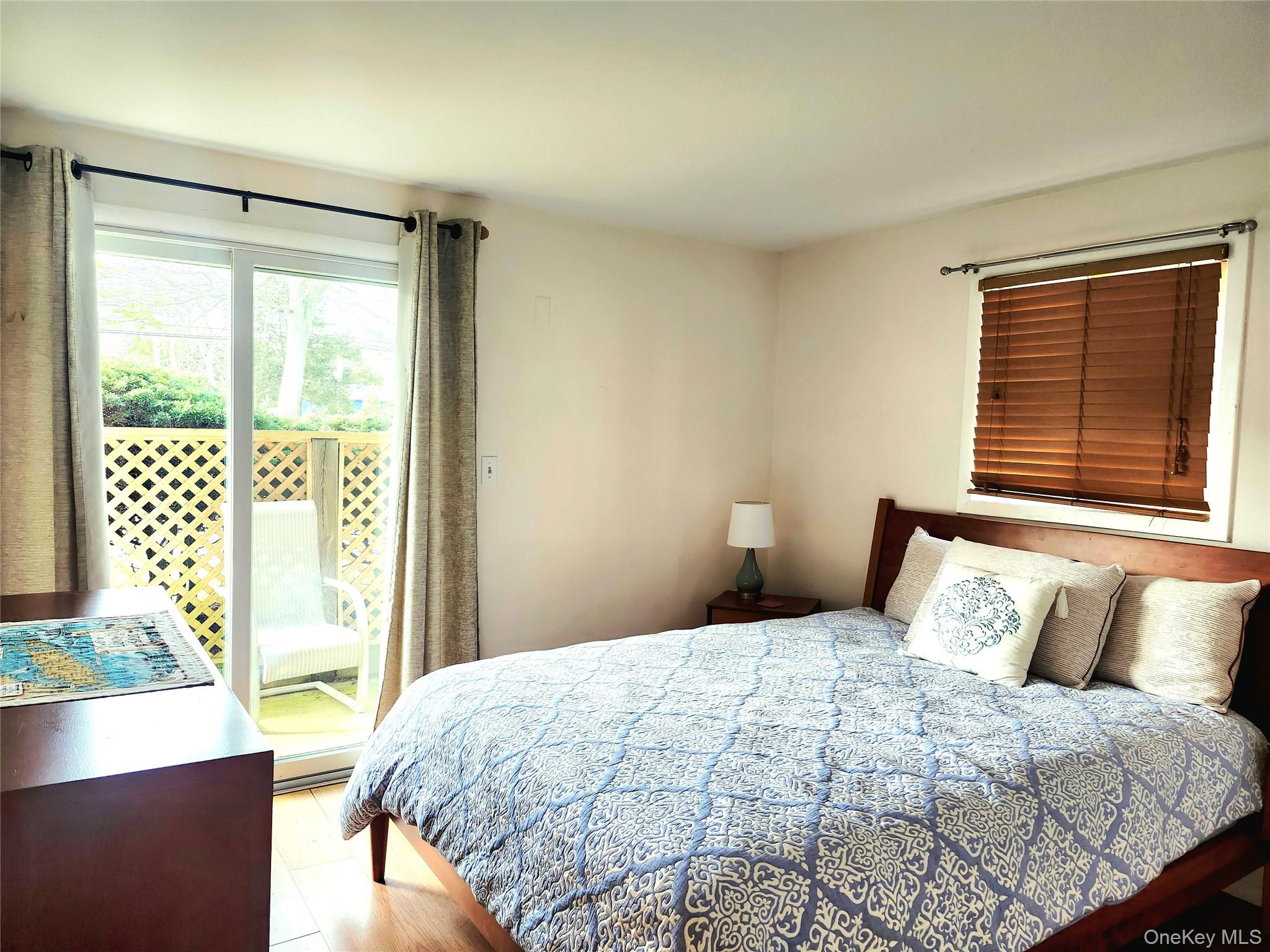 95 Springville Road South, Unit 3 Hampton Bays, NY 11946 - Photo 14 of 17 a bedroom with a large bed and a large window