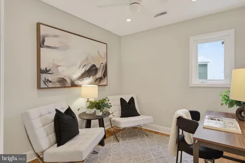 a living room with furniture and a painting on the wall