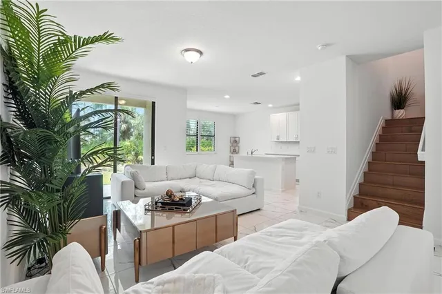 a kitchen with stainless steel appliances kitchen island granite countertop a sink and a refrigerator