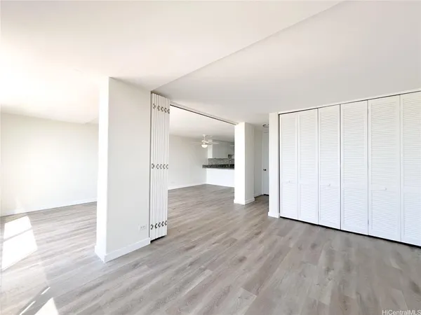 an empty room with wooden floor and windows