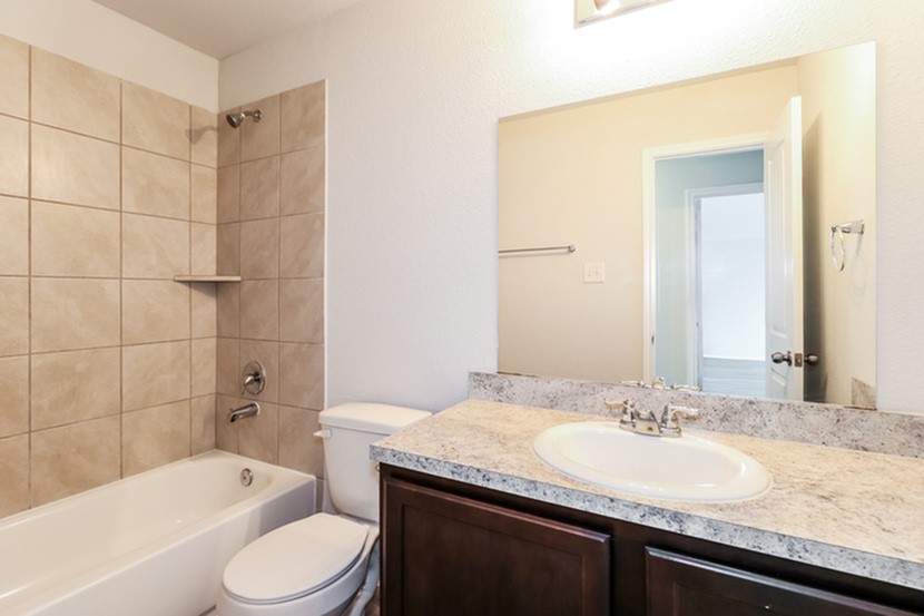 3765 Alexus Drive Conroe, TX 77301 - Photo 11 of 19 a bathroom with a granite countertop sink toilet mirror and bathtub