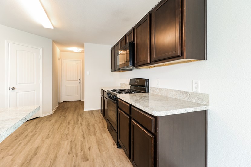 3765 Alexus Drive Conroe, TX 77301 - Photo 5 of 19 a kitchen with a sink and a stove top oven with wooden floor