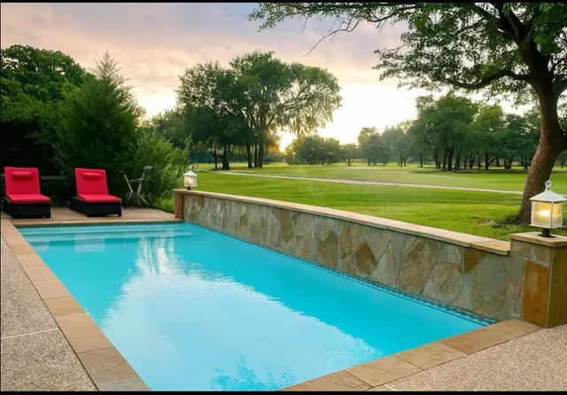 a view of a swimming pool with a yard