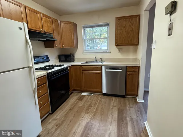 a kitchen with stainless steel appliances granite countertop a stove a sink dishwasher and a refrigerator