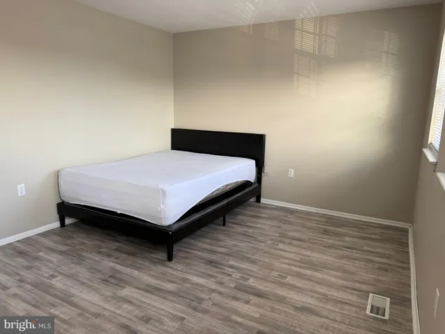 a room with a bed and wooden floor