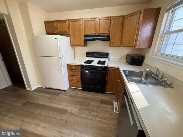 a kitchen with stainless steel appliances a stove a sink and wooden cabinets