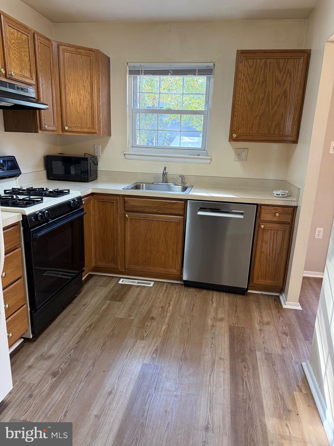 34 King Charles Circle, Unit 34 Rosedale, MD 21237 - Photo 9 of 25 a kitchen with granite countertop wooden floors and stainless steel appliances