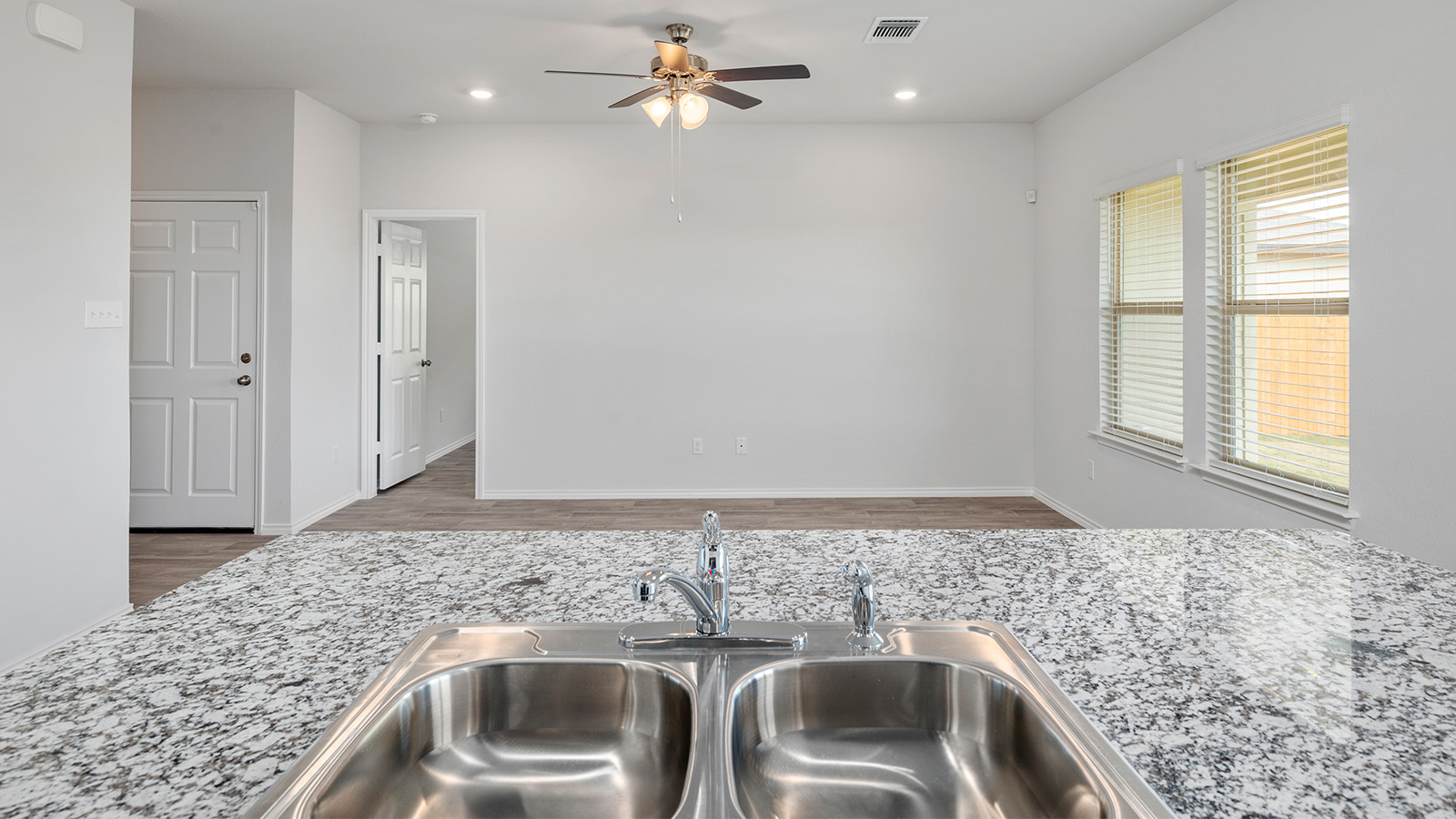 1418 Victory Rnch Trail Killeen, TX 76549 - Photo 5 of 22 A chef's delight, this kitchen features a double stainless steel sink integrated into granite countertops, overlooking a spacious living area.