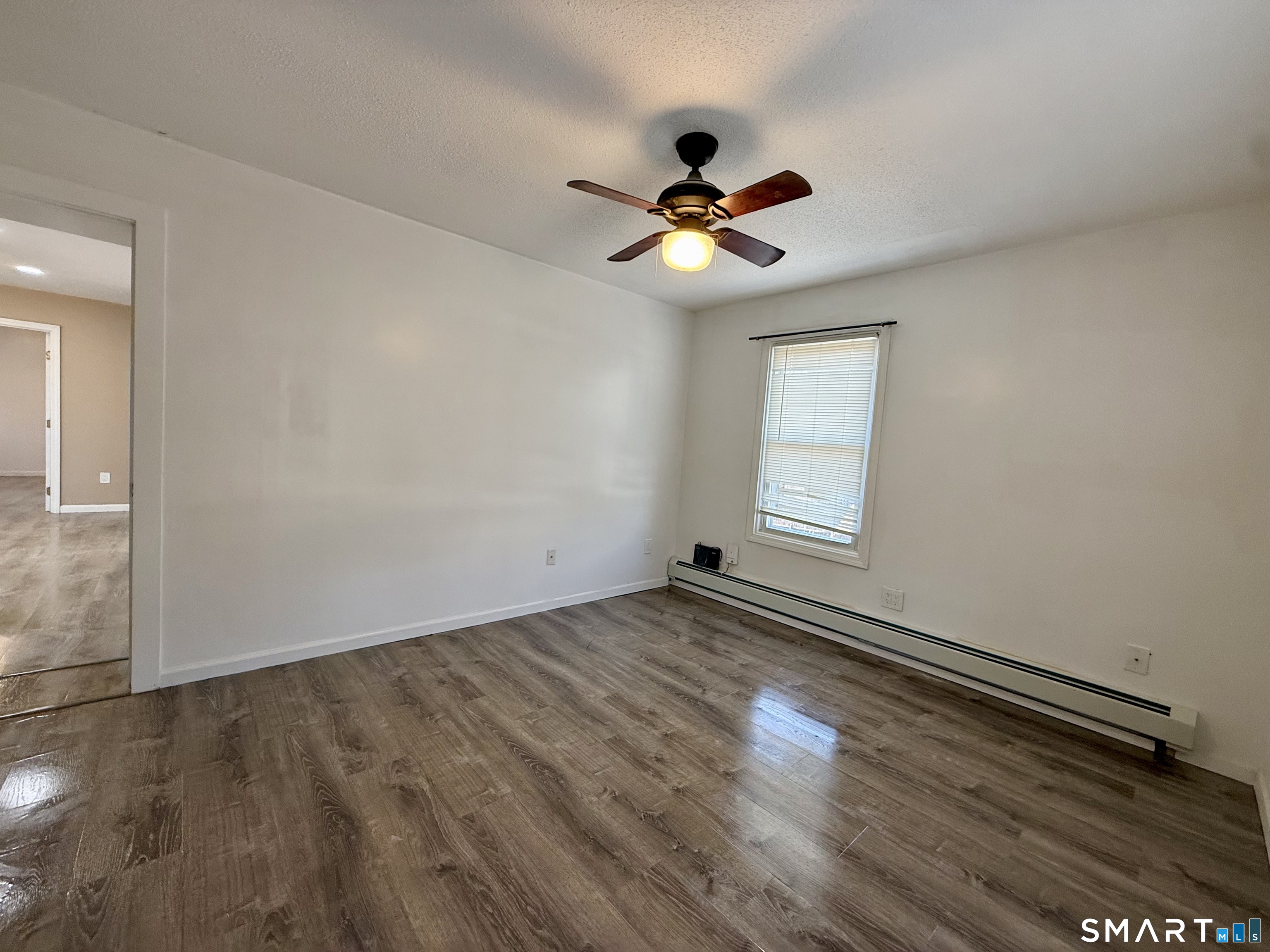 8 Scott Street, Unit 2 Naugatuck, CT 06770 - Photo 14 of 15 an empty room with wooden floor chandelier fan and windows