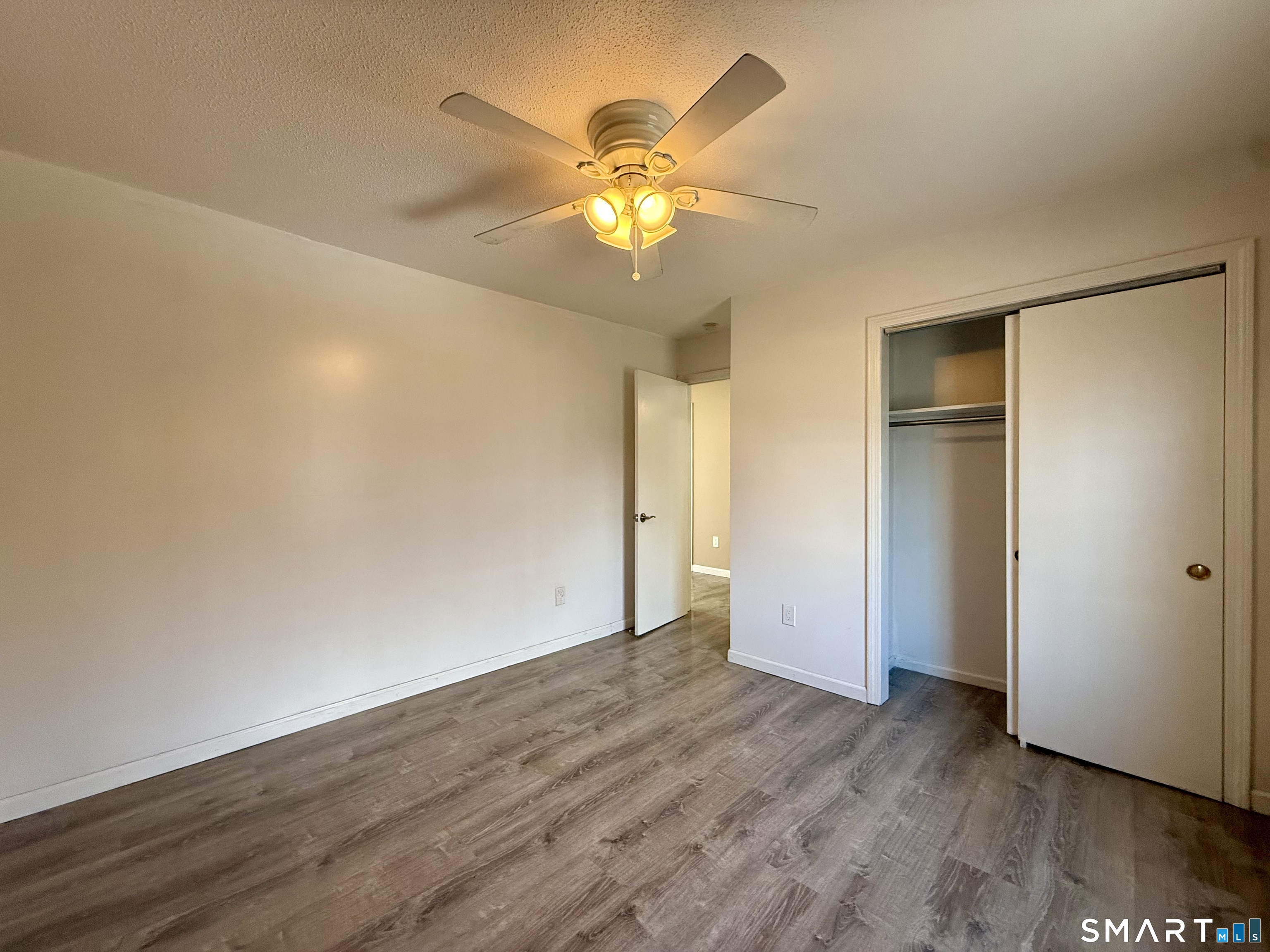 8 Scott Street, Unit 2 Naugatuck, CT 06770 - Photo 9 of 15 a view of an empty room with wooden floor and a ceiling fan