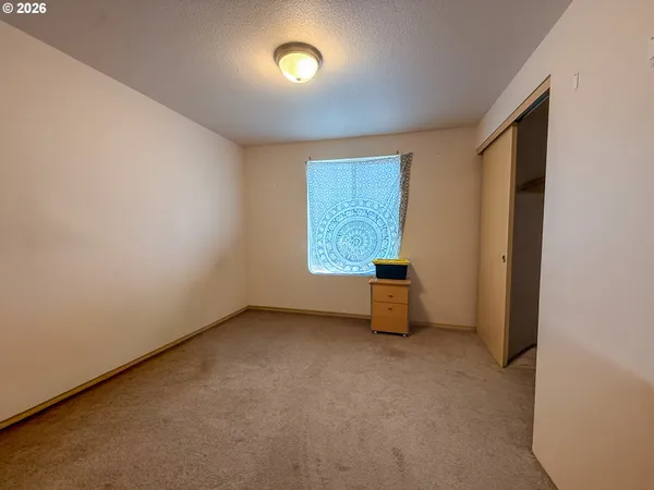 an empty room with windows and closet