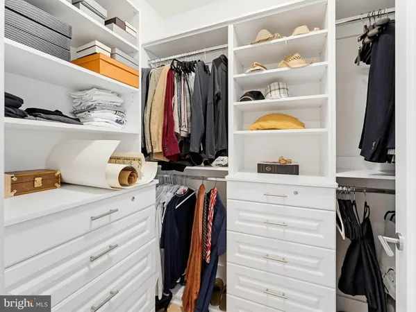 a view of walk in closet with clothes and shoes