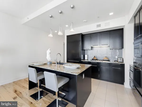 a kitchen with granite countertop a sink stainless steel appliances and cabinets