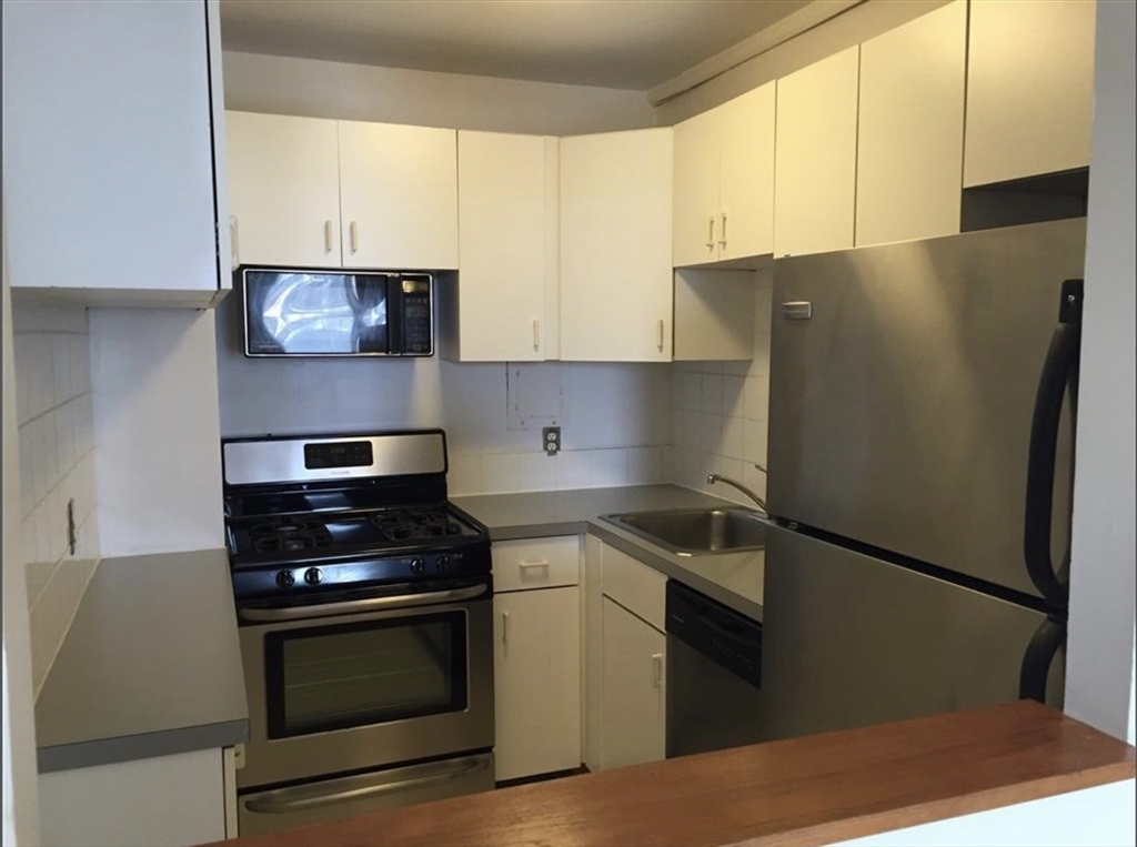 33 Pond Avenue, Unit 813 Brookline, MA 02445 - Photo 1 of 6 a kitchen with stainless steel appliances a refrigerator sink and stove