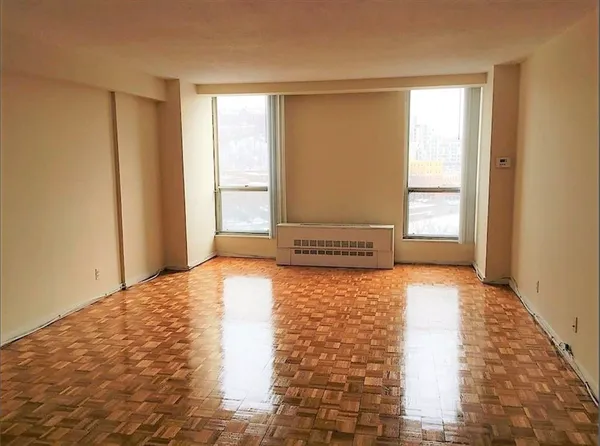 a view of empty room with wooden floor