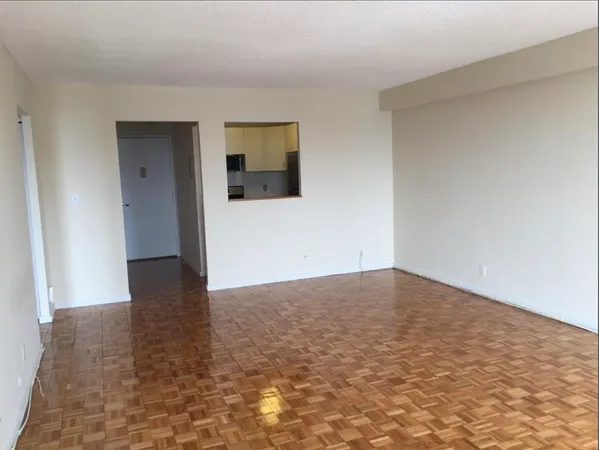 a view of an empty room and wooden floor