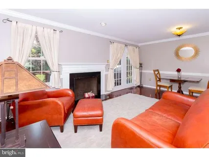 a living room with furniture a fireplace and a large window
