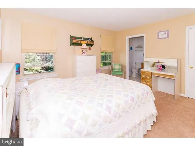 a bedroom with a bed and a flat tv screen on dresser