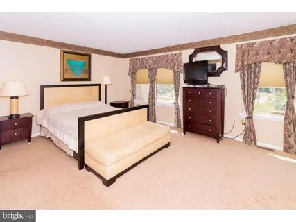 a bedroom with a bed and painting on the wall