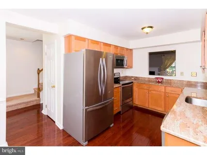 a kitchen with a refrigerator sink and cabinets