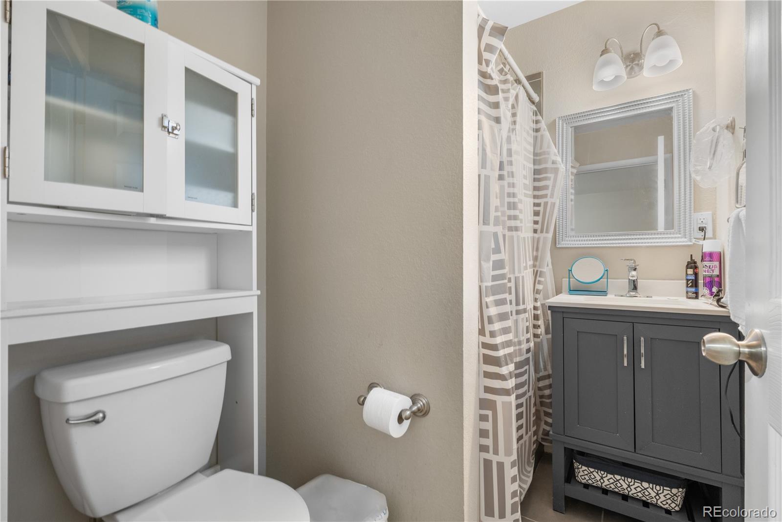 6572 Kipling Street Arvada, CO 80004 - Photo 11 of 18 a bathroom with a toilet sink and mirror