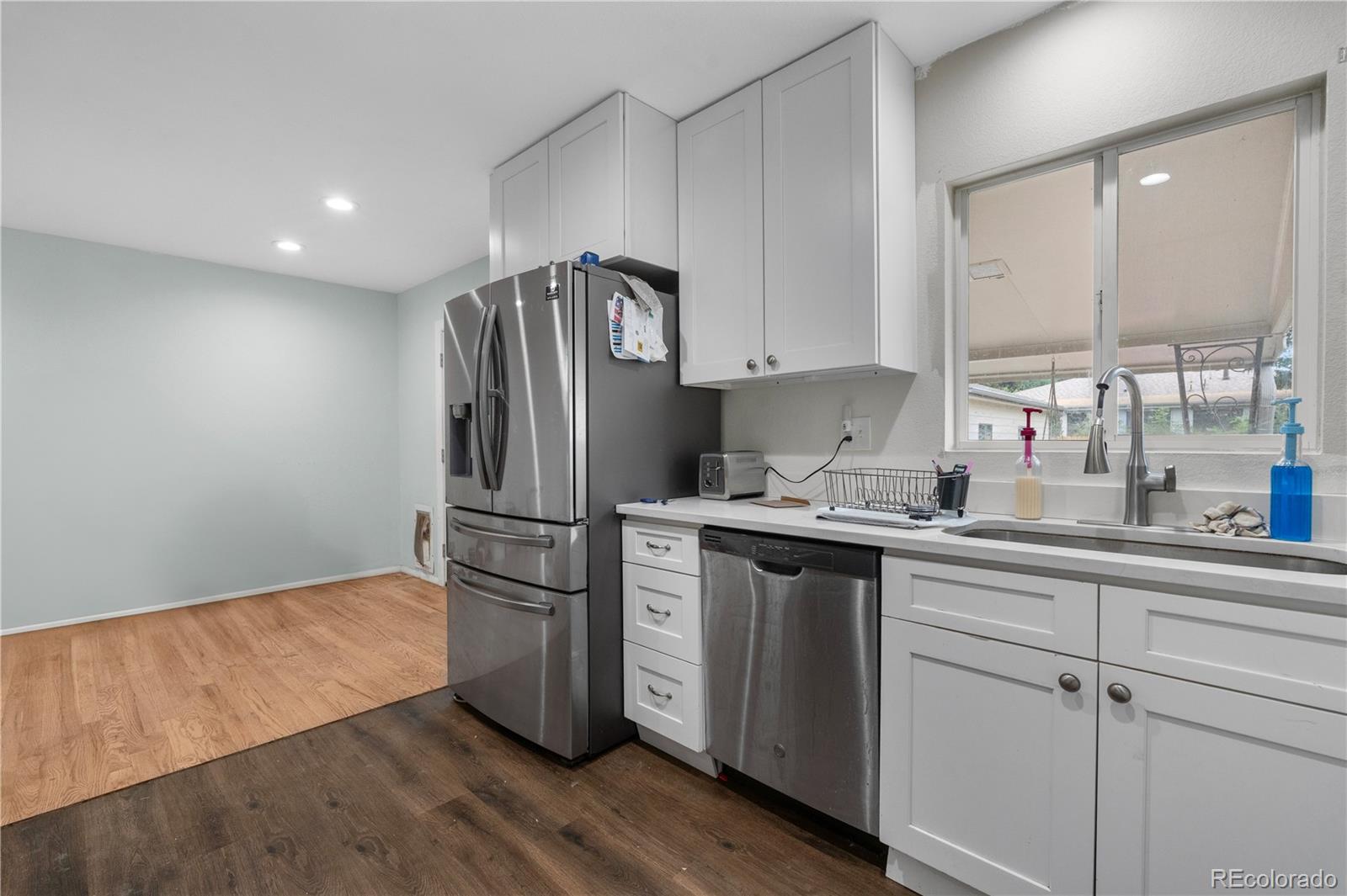 6572 Kipling Street Arvada, CO 80004 - Photo 7 of 18 a kitchen with stainless steel appliances a refrigerator sink and cabinets