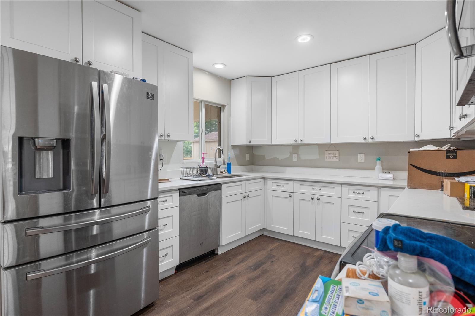 6572 Kipling Street Arvada, CO 80004 - Photo 8 of 18 a kitchen with a refrigerator stove and sink