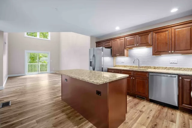 a kitchen with stainless steel appliances granite countertop a sink stove and wooden floor