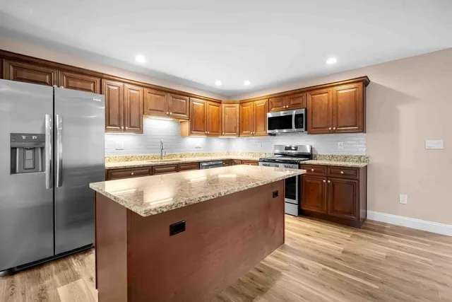 a kitchen with stainless steel appliances granite countertop a sink stove and refrigerator