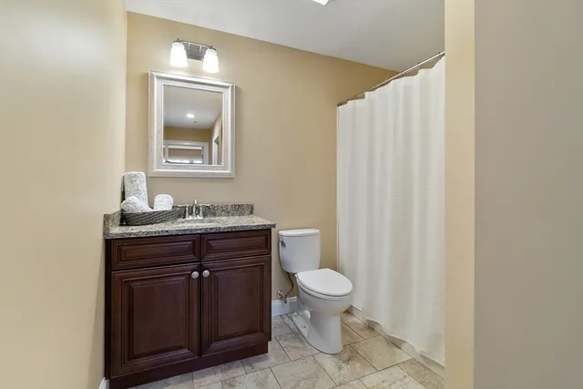 a bathroom with a toilet a sink and mirror