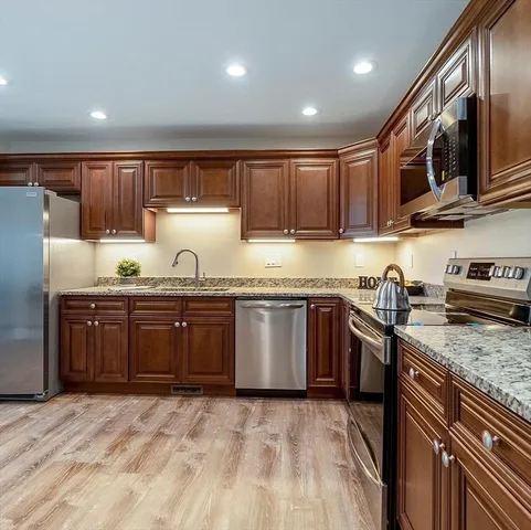 a kitchen with stainless steel appliances granite countertop a stove a sink dishwasher and a refrigerator