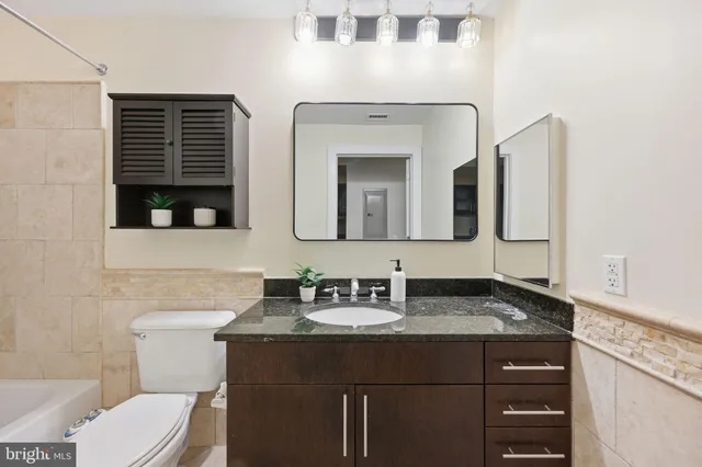 a bathroom with a toilet sink and mirror