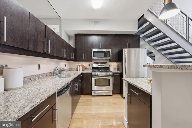 a kitchen with granite countertop stainless steel appliances and sink