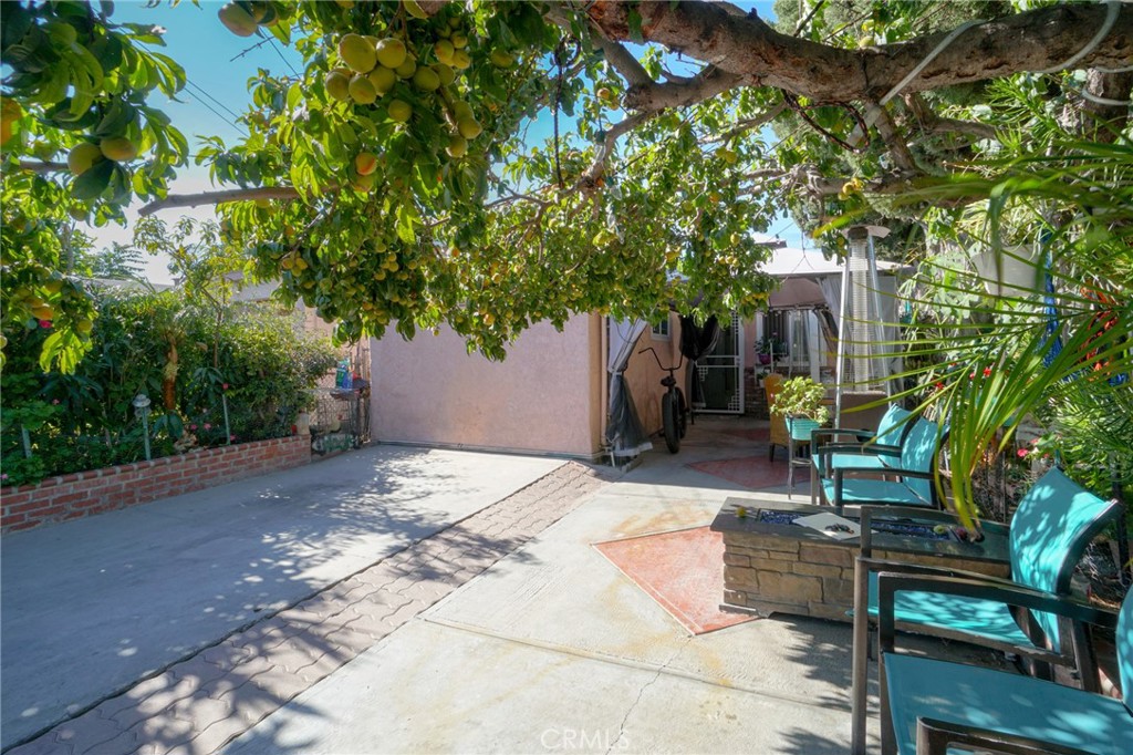 a patio with table and chairs and potted plants