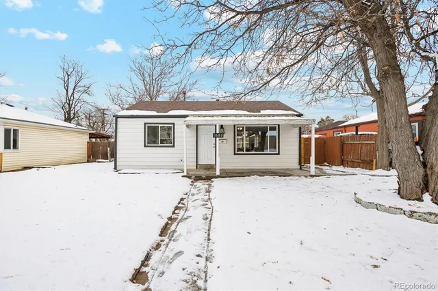 a front view of a house with a yard covered with snow in front of house