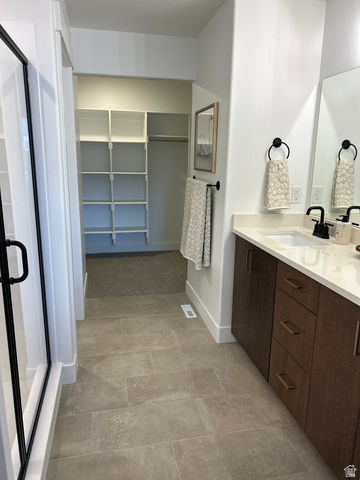 2011 West 1150 South, Unit 1042 Payson, UT 84651 - Photo 29 of 39 Photos are of model home.Modern bathroom featuring a glass-enclosed shower with matte black hardware, dual wood-finish vanity with countertop, and large format tile flooring
