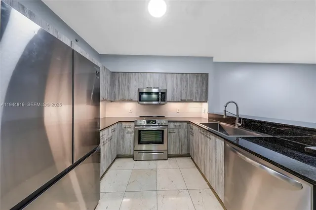 a kitchen with stainless steel appliances granite countertop a sink and a stove