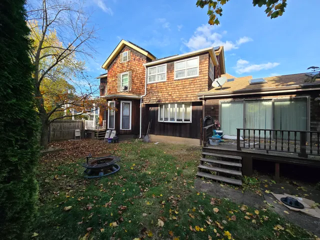 a view of house with a yard and deck