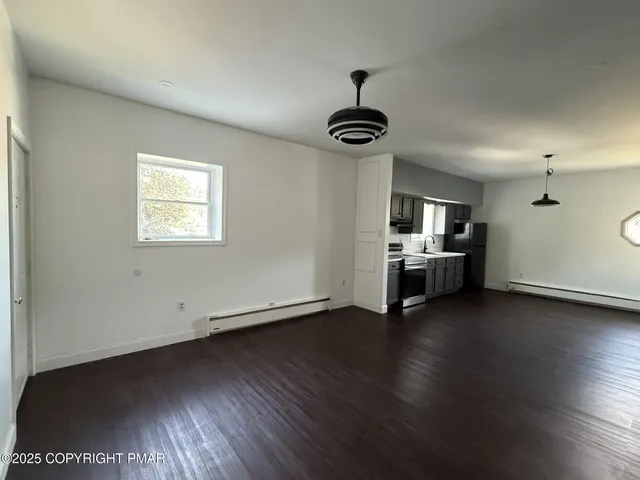 a view of kitchen and hall with wooden floor