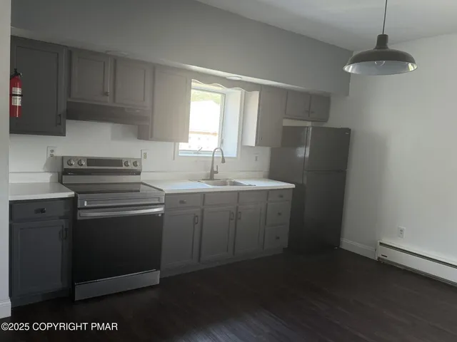 a kitchen with a sink cabinets and wooden floor