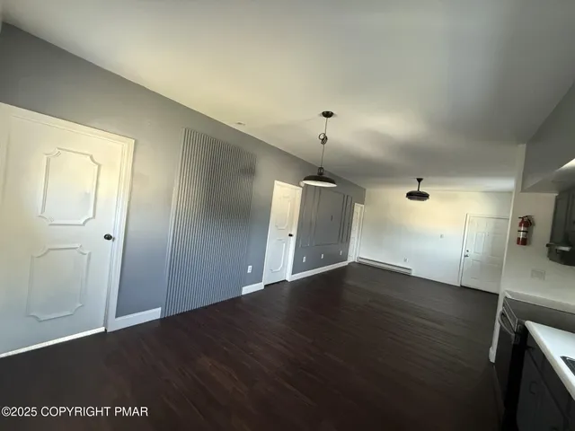 an empty room with wooden floor and mirror