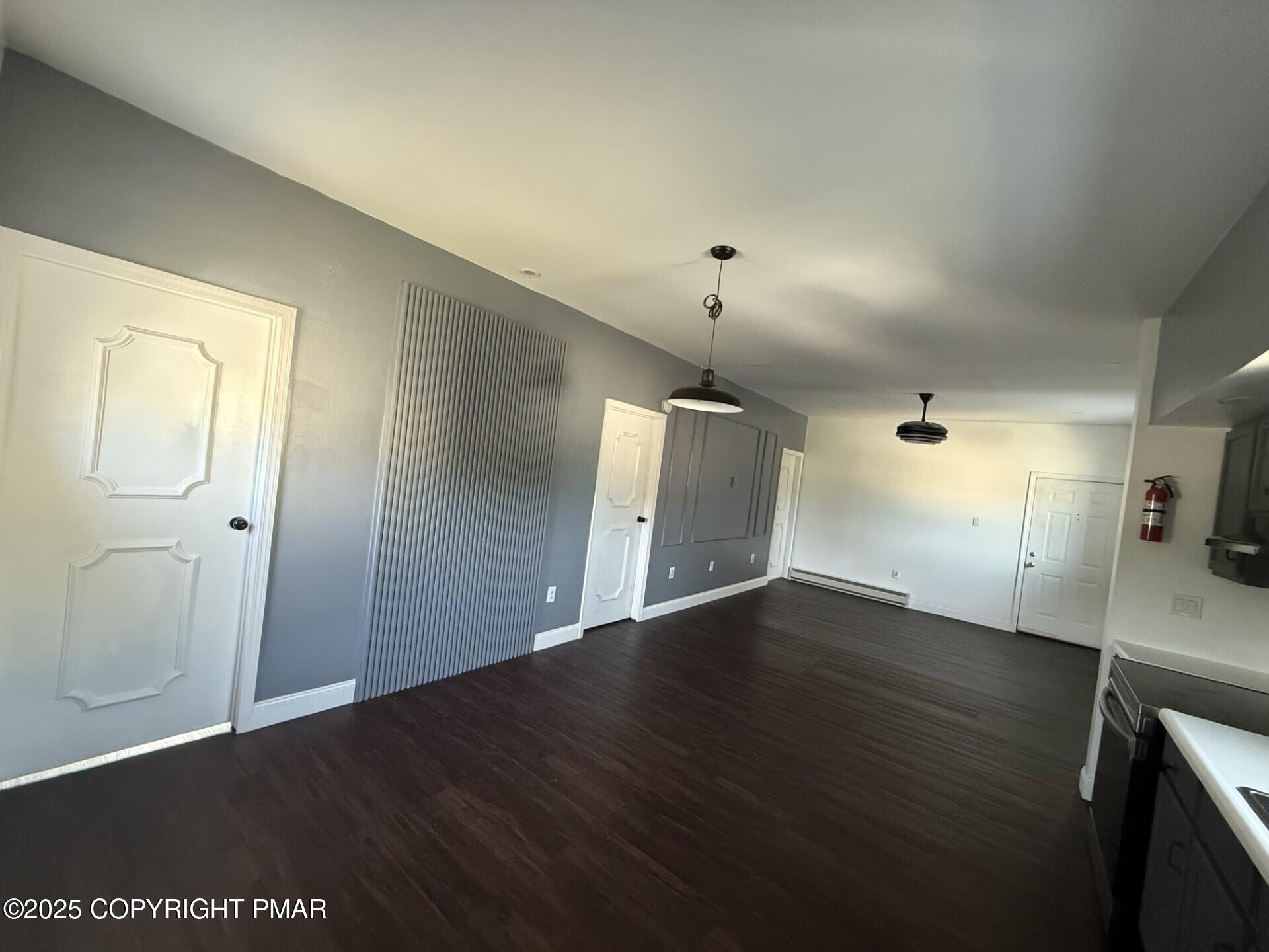 132 East Main Street, Unit 1C Girardville, PA 17935 - Photo 4 of 13 an empty room with wooden floor and mirror