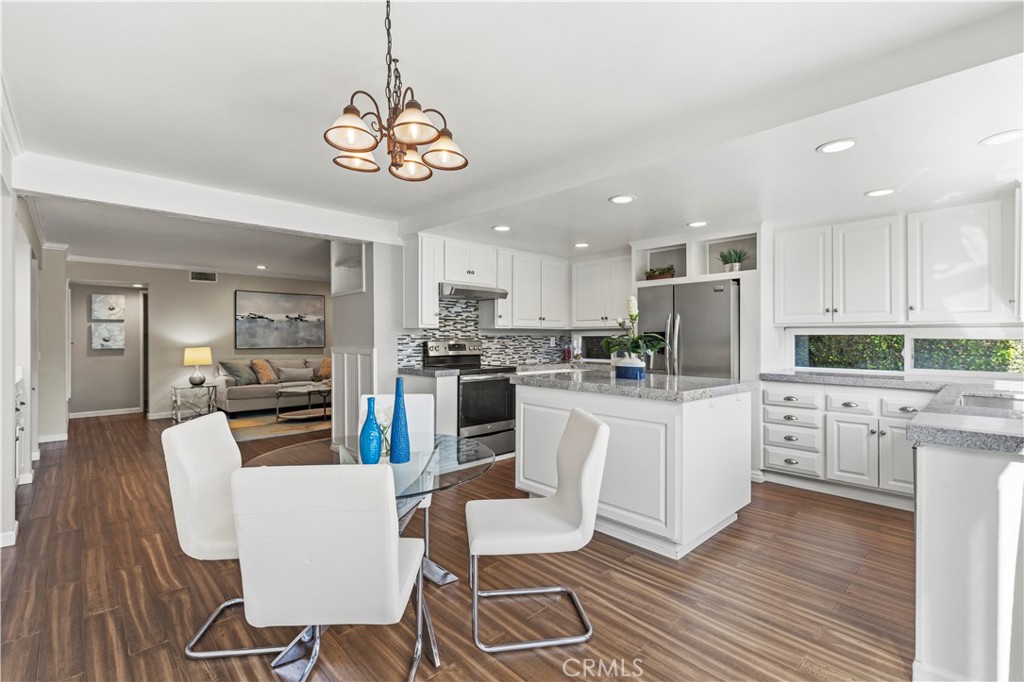13 Recodo Irvine, CA 92620 - Photo 18 of 71 a kitchen with white cabinets stainless steel appliances and dining table