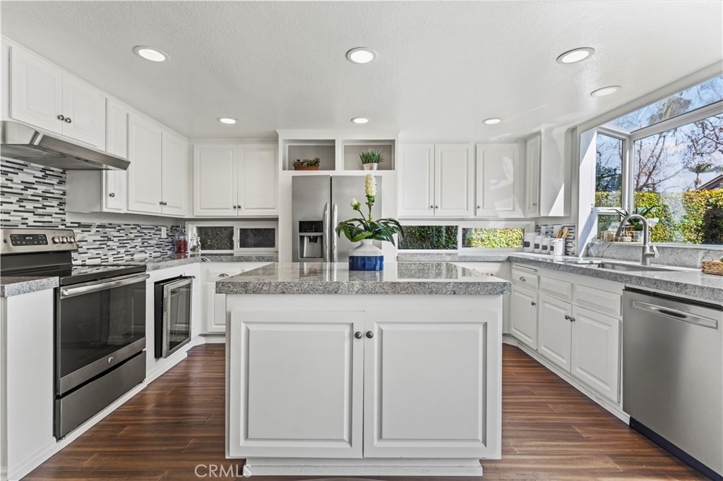 13 Recodo Irvine, CA 92620 - Photo 19 of 71 a kitchen with kitchen island granite countertop a sink cabinets and stainless steel appliances